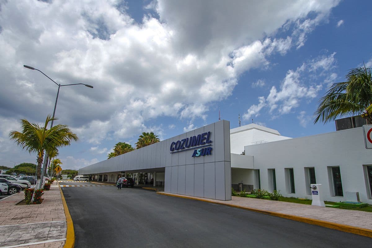 Entrance to Cozumel International Airport, lined with palm trees