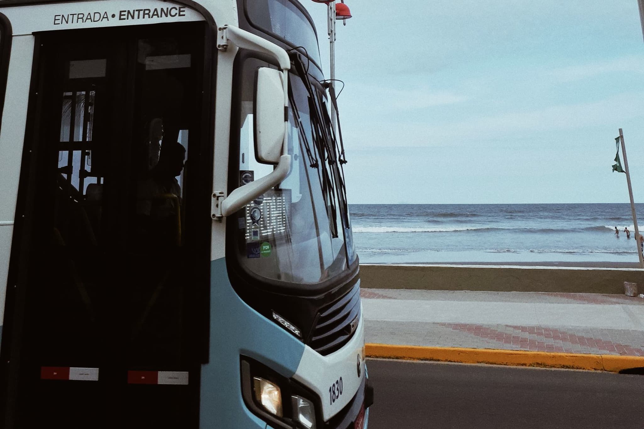 Intercity coach parked beside the sea, its door marked Entrance