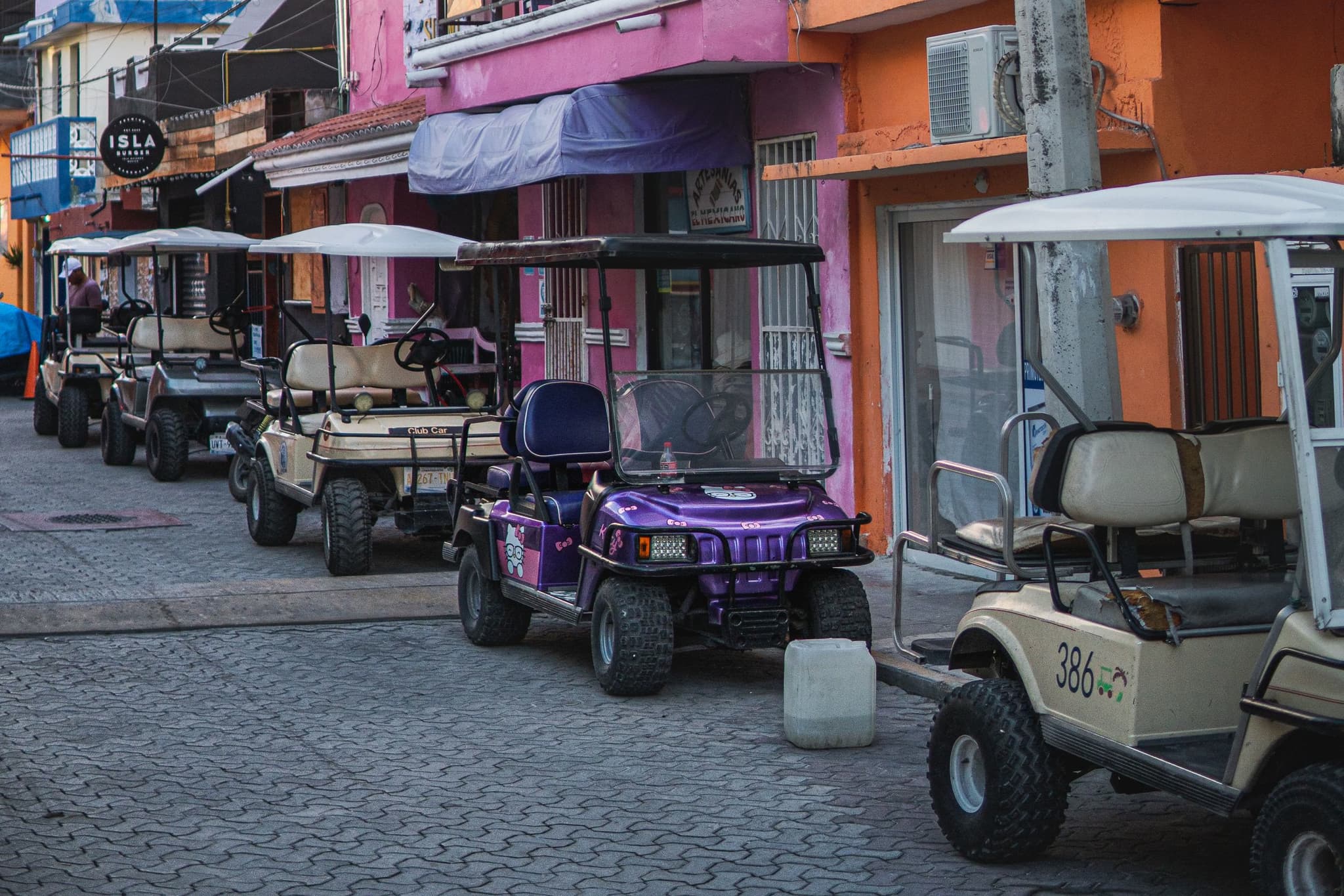 Golf carts parked along a cobbled street in the centre of Isla Mujeres