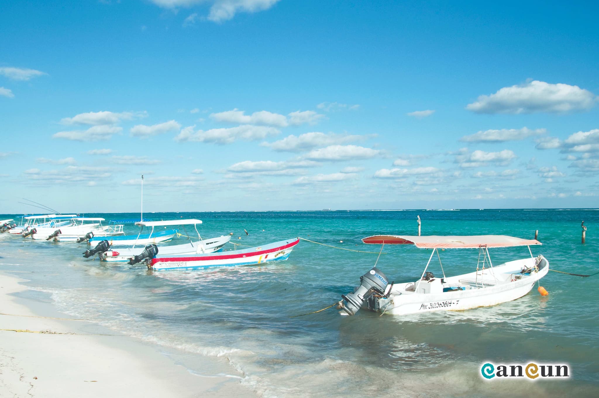 Beach in Puerto Morelos with fishing boats and the leaning lighthouse