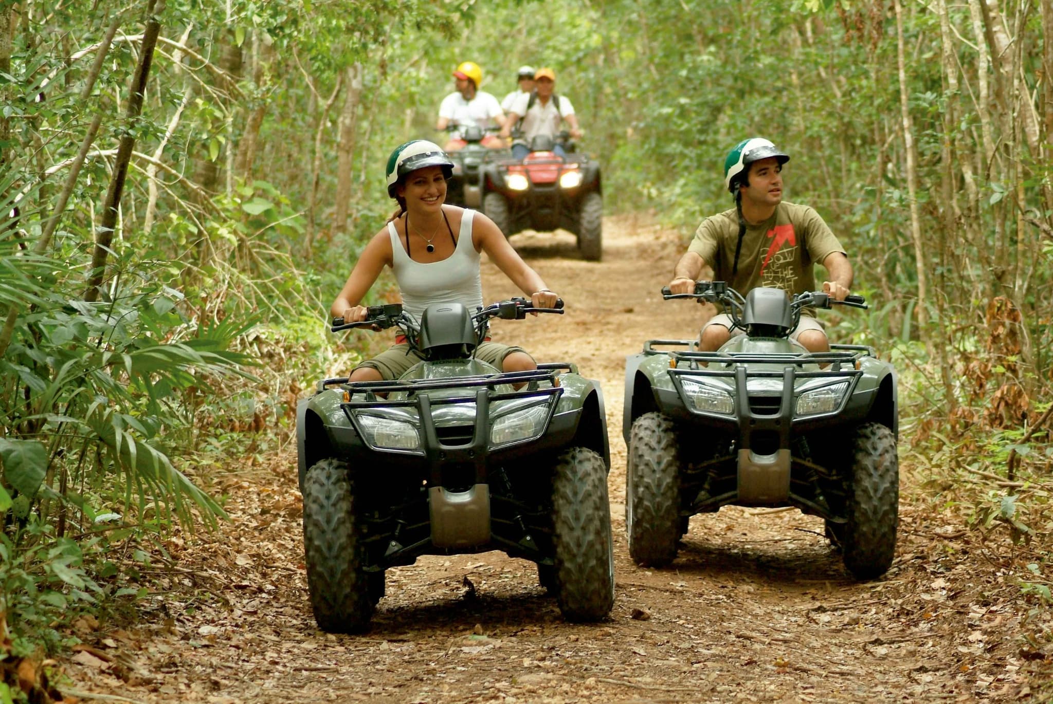 Group riding quad bikes along a jungle trail