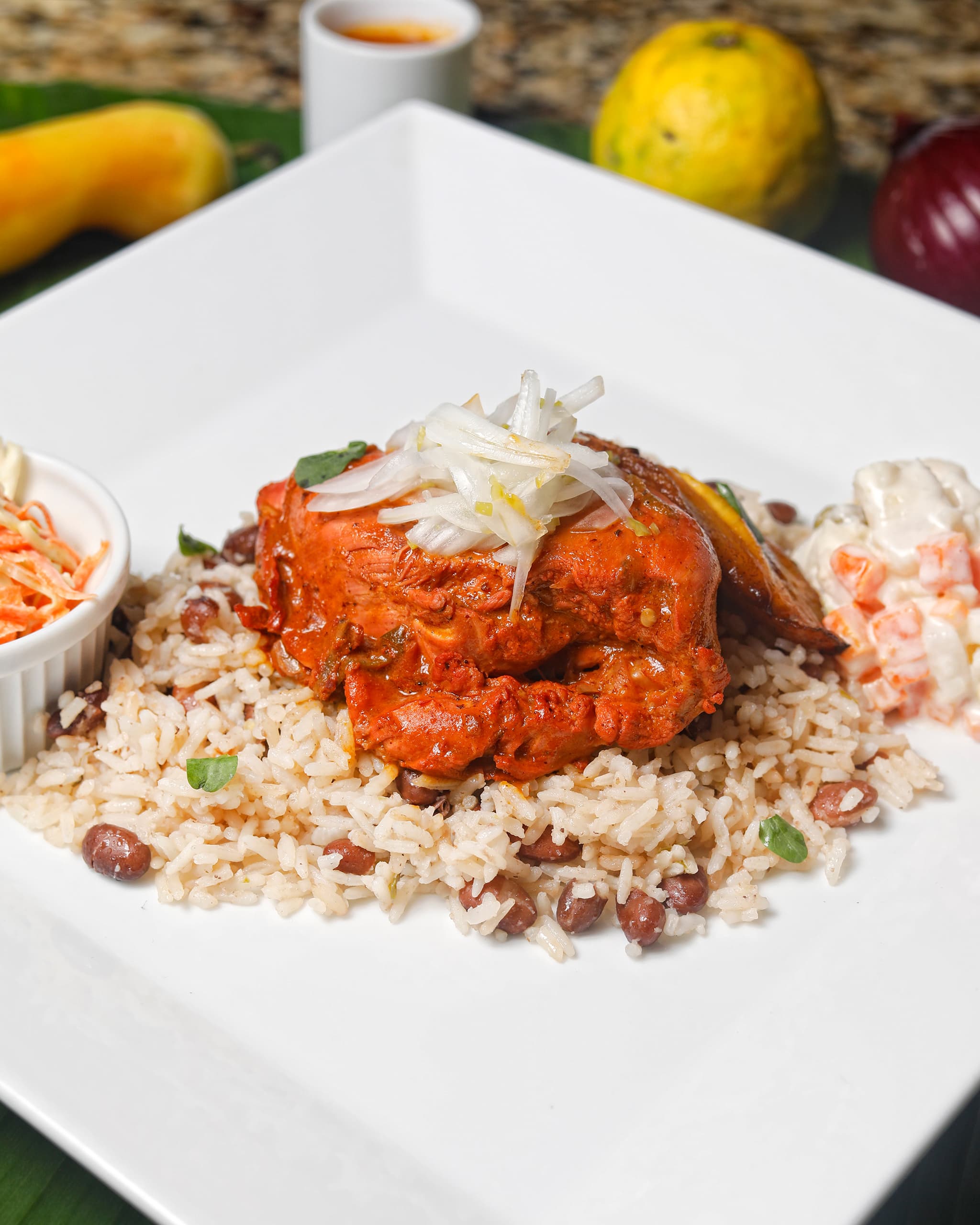A stew in adobo served over rice and beans
