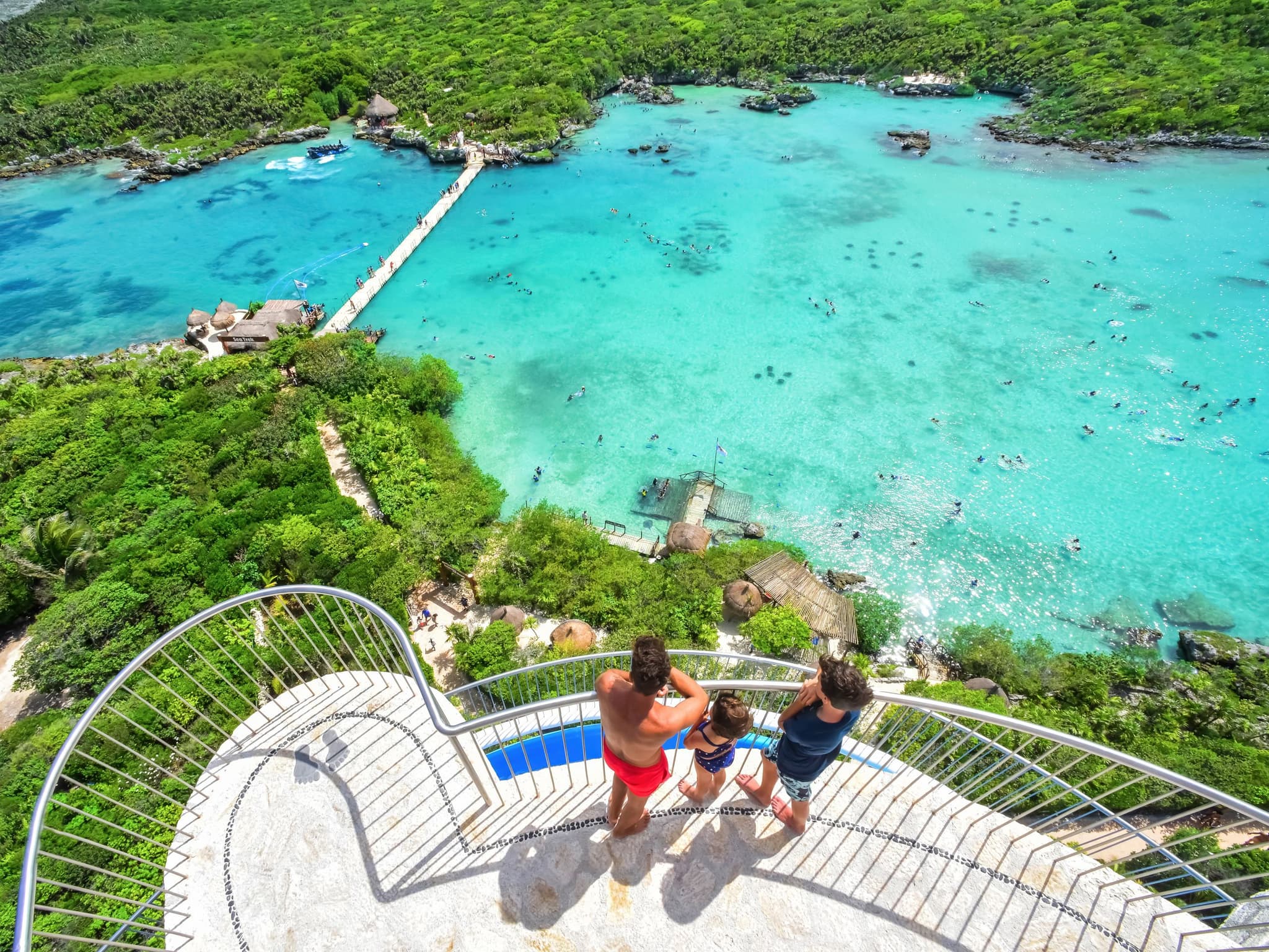 Family at a lookout over a turquoise cove