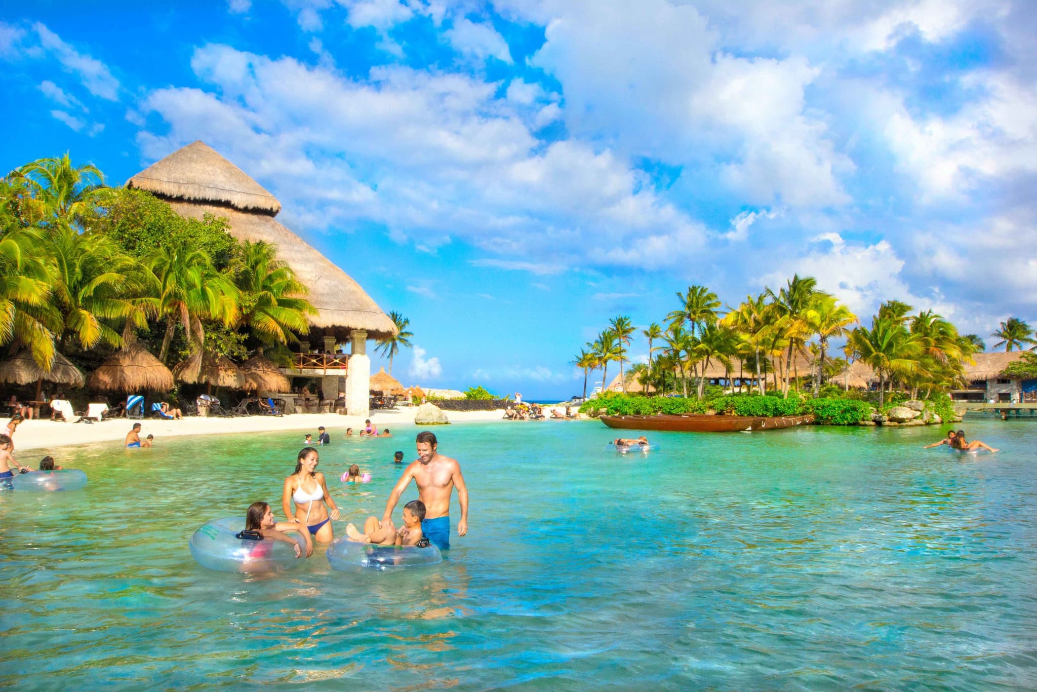Family with children floating in a clear-water cove