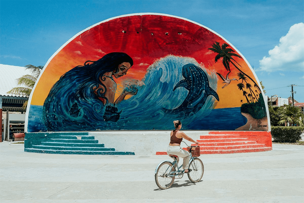 Cyclist in front of a whale shark mural in Holbox
