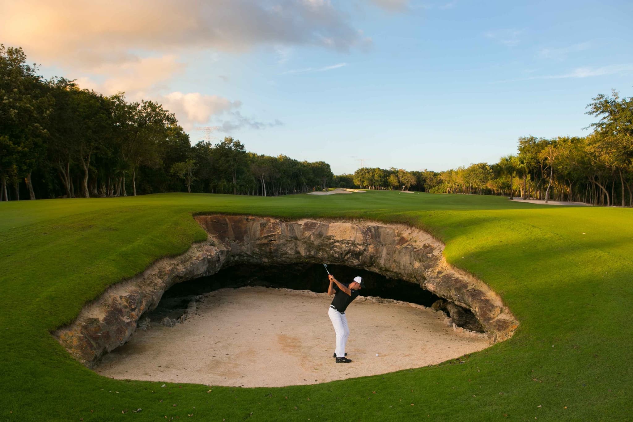 Golfer playing out of a deep bunker