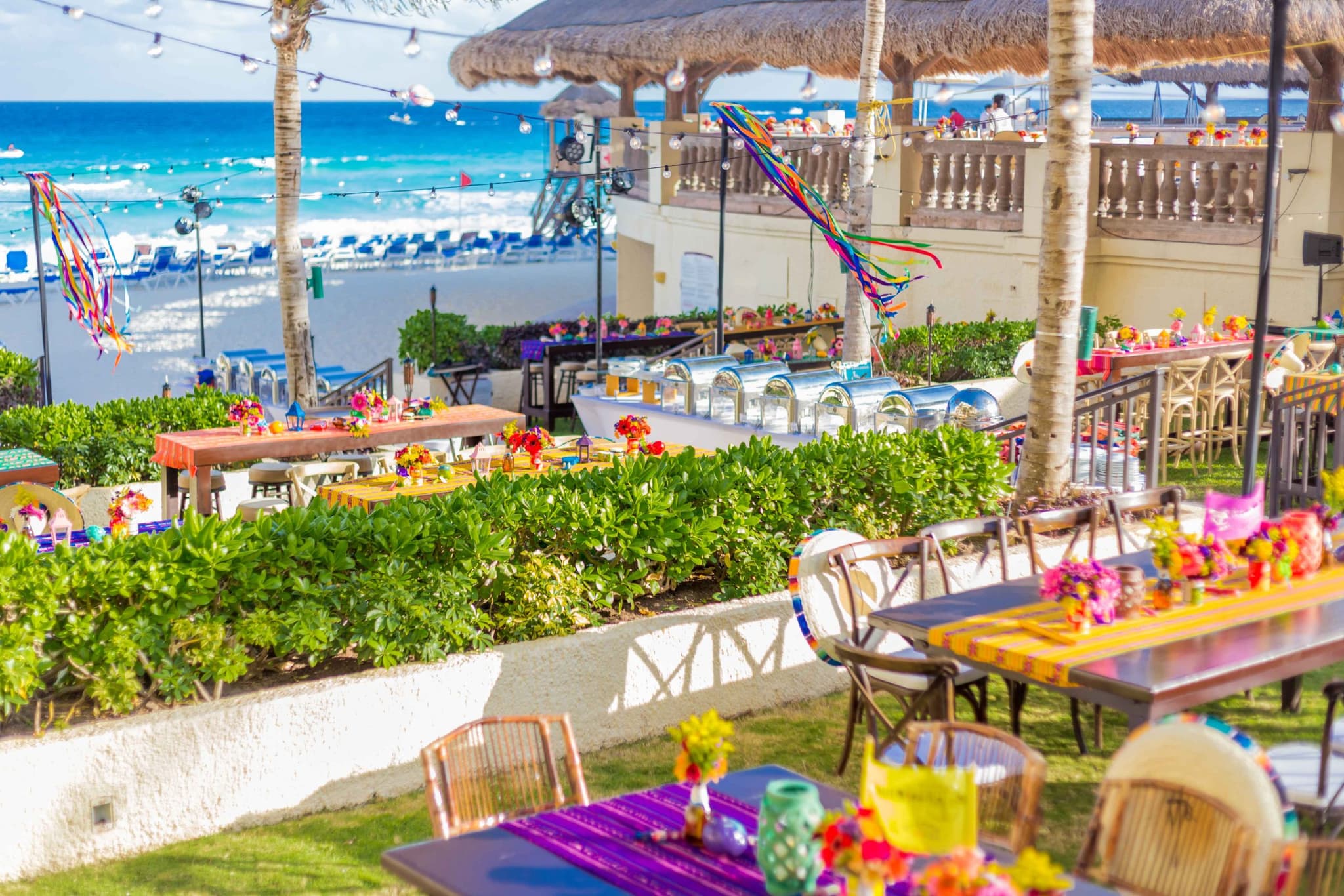 Dinner set under a palapa lit with coloured lanterns
